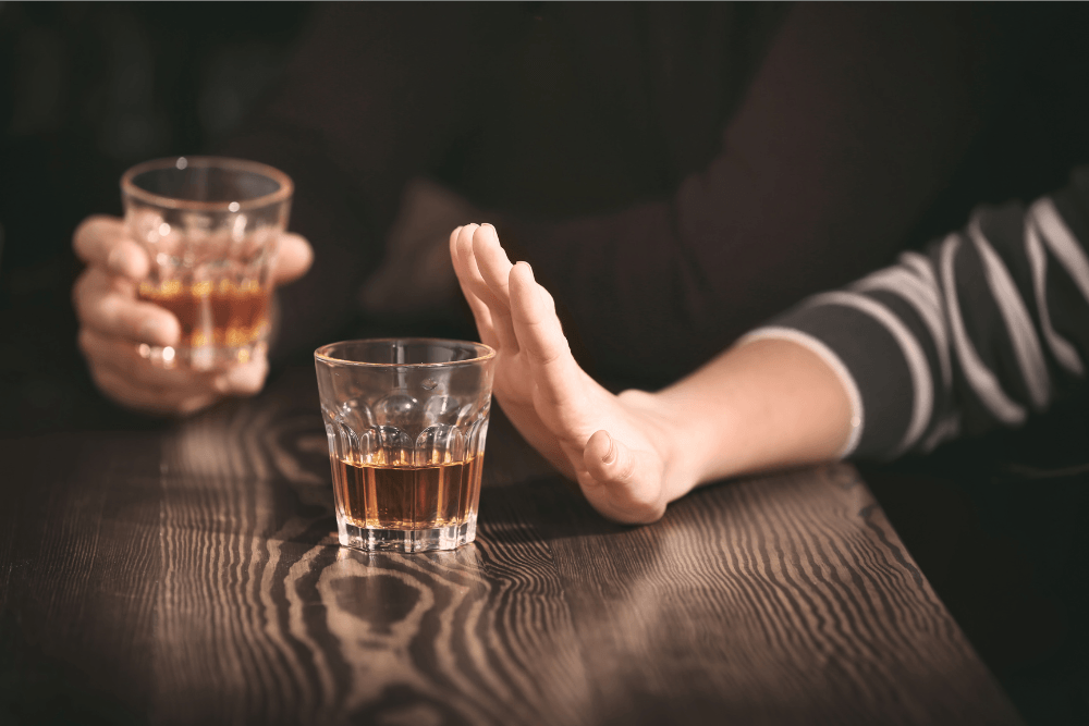 Hand held up in ‘no’ to a glass of alcohol. Many non-12-step recovery programs emphasize personal responsibility.