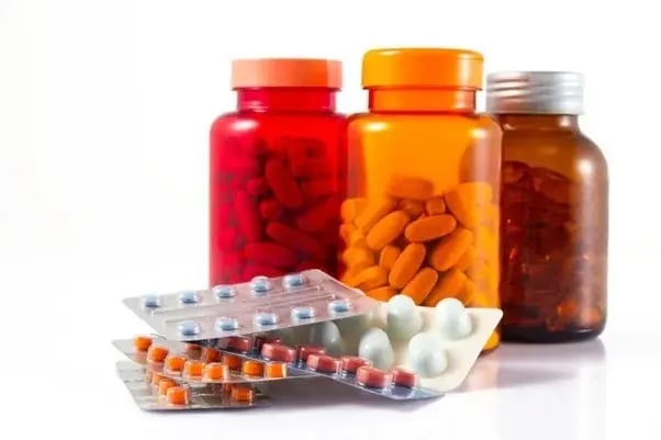 Prescription pill bottles and blister packs representing Adderall and Suboxone medications.