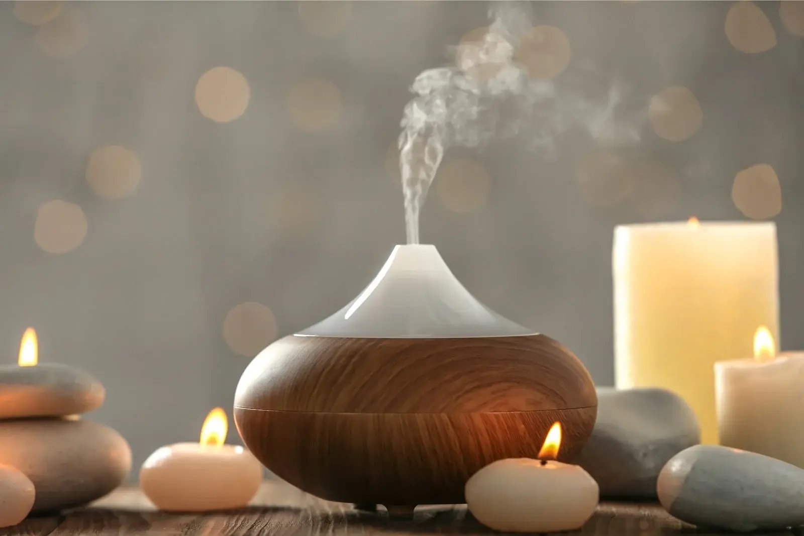 Aromatherapy diffuser with essential oils for addiction recovery, surrounded by tealights.