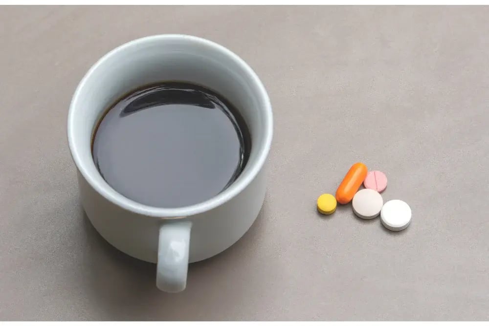 A coffee cup sits next to pills, demonstrating the study drugs and legitimate options students utilize.