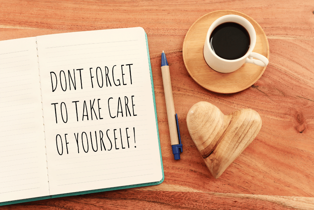 Coffee, pen, and notebook on table. Avenues Recovery reminds spouses of alcoholics to practice self care.