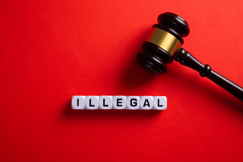 “Illegal” written on blocks with a gavel nearby. Detox drinks for drug tests may be illegal.