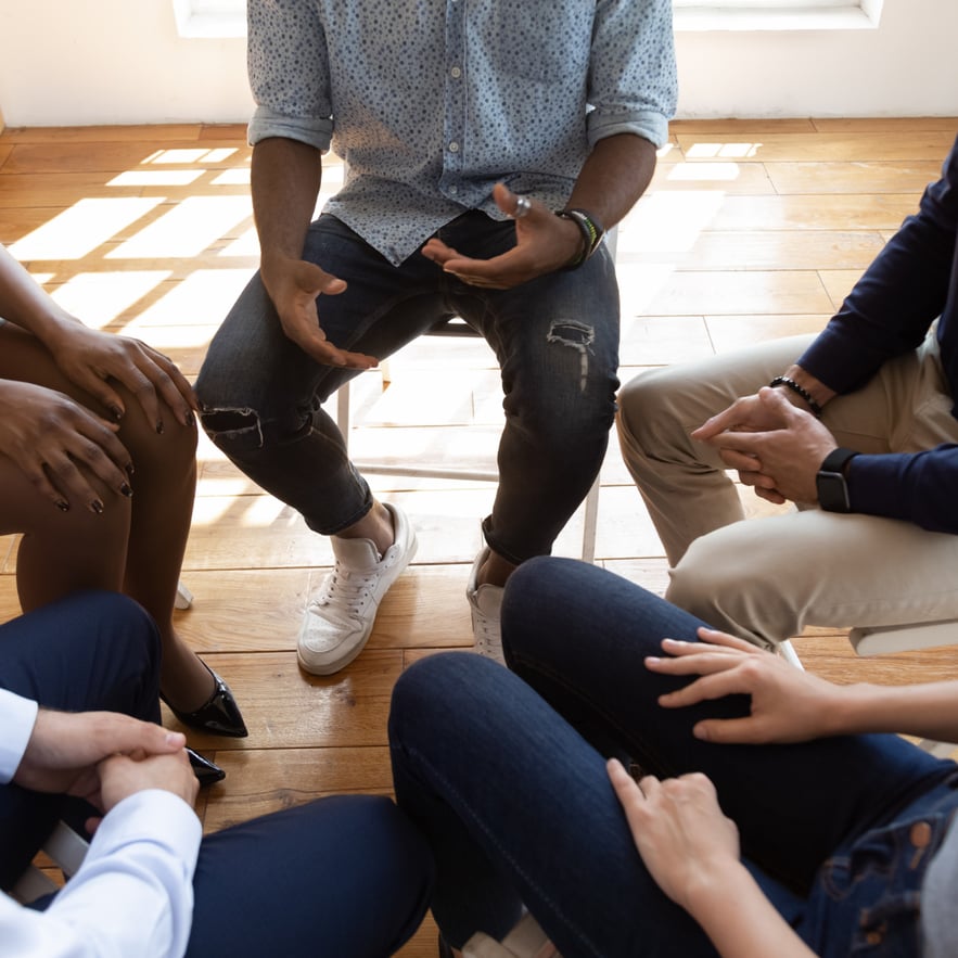 Group sitting in a therapy circle at rehab. Does Medicaid cover rehab?