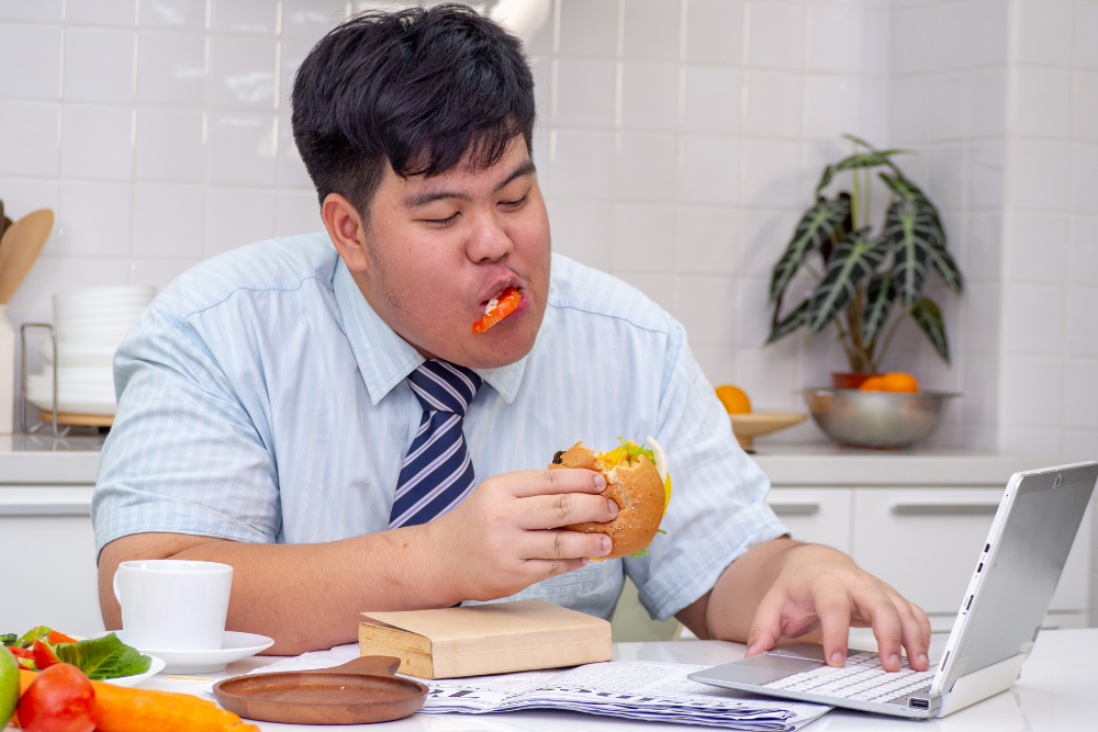 Man eating burger with gusto, unaware that he's binge-eating since he recently quit stimulants