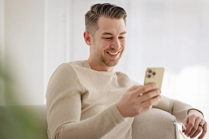 Man in recovery using his phone at one of the rehabs that allow cell phones; Avenues Recovery.