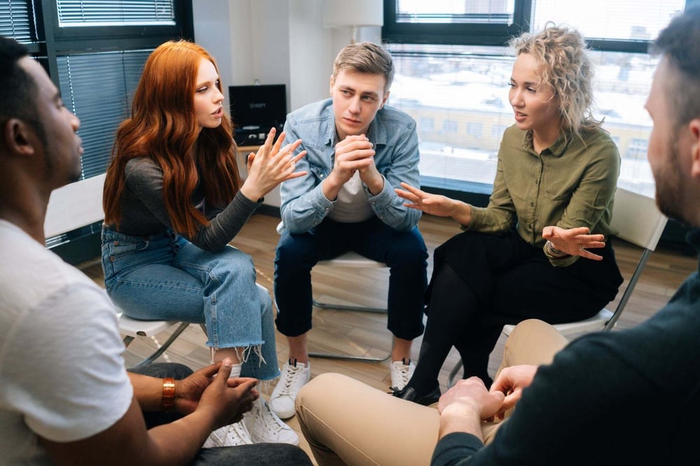 Group members share experiences and support during an addiction recovery meeting.
