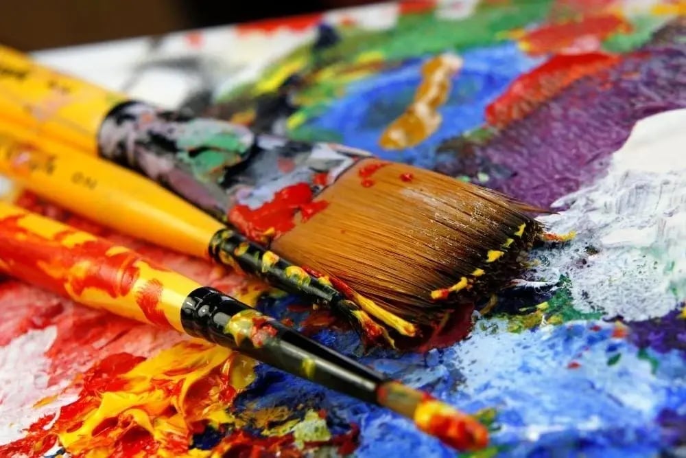 Close-up of paintbrushes on vibrant palette, symbolizing creative sober activities like learning how to paint