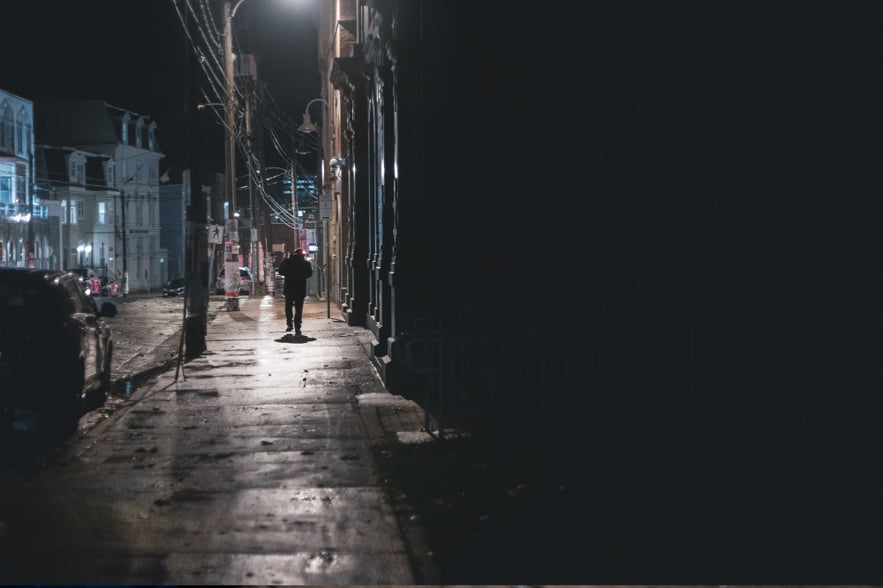 A person in a dark city street, illustrating slang and street names for crack cocaine.