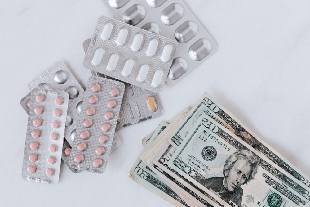 Blister packs of pills and money. What is PHP treatment and does insurance cover it?