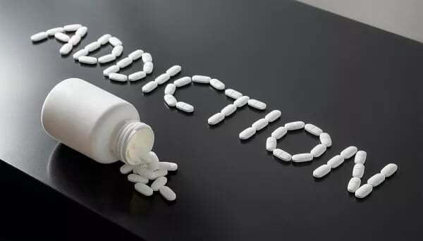 Bottle of spilled pills spelling ‘addiction’. A list of recovery words helps you navigate addiction recovery.