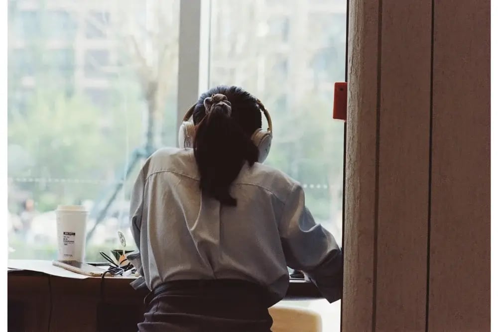 A student studies with coffee and headphones, healthier alternatives to study drugs.