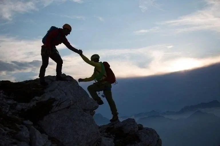Two people hiking at sunrise taking part in adventure therapy for addiction