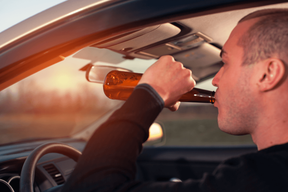 Young man drinking beer while driving after quitting court-ordered rehab, possibly facing extended jail time