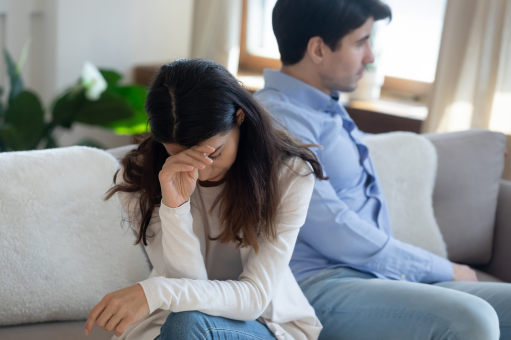 A distant couple sitting in silence, reflecting relationship issues caused by Tramadol addiction.