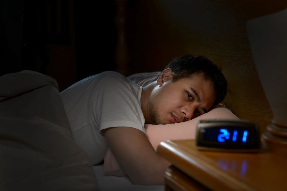 Image of sleepless man in bed as Avenues Recovery explains why does alcohol make me sleepy