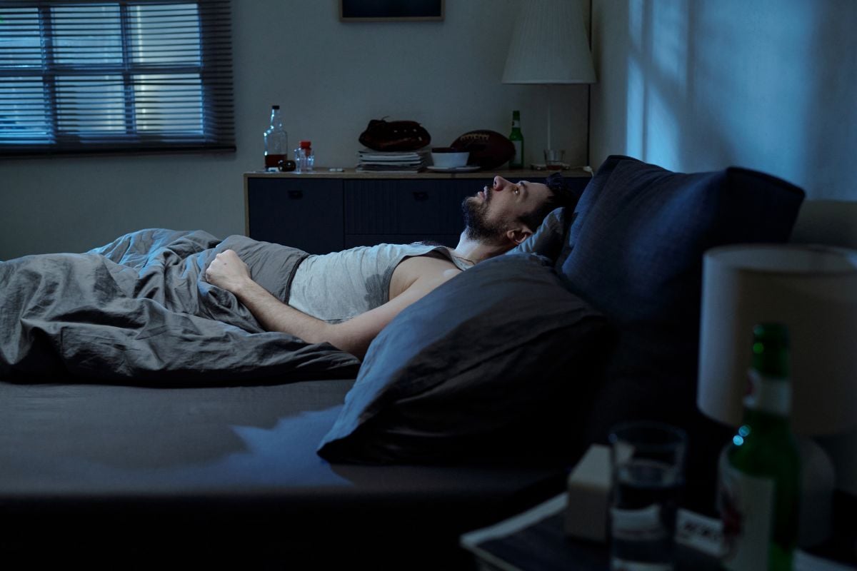 Image of sleepless man in bed as Avenues Recovery explores grief and addiction