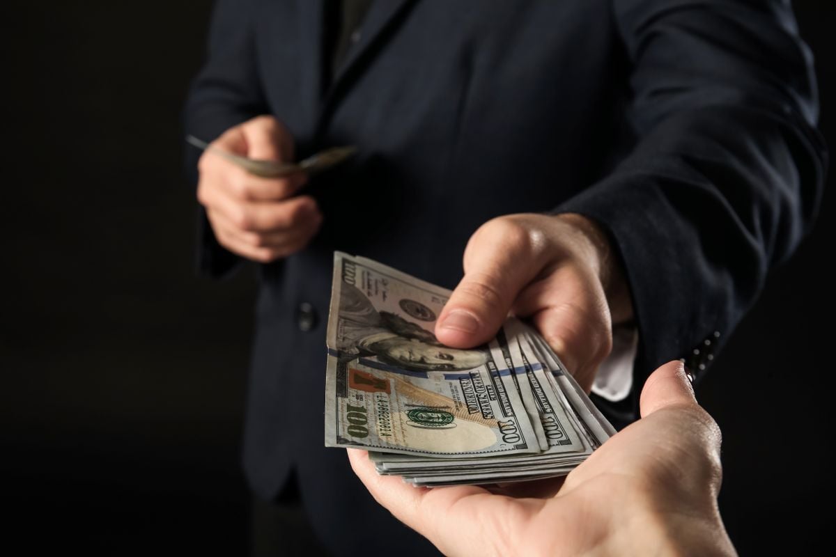 Image of handing over cash as Avenues Recovery explores how rehab fits into your life