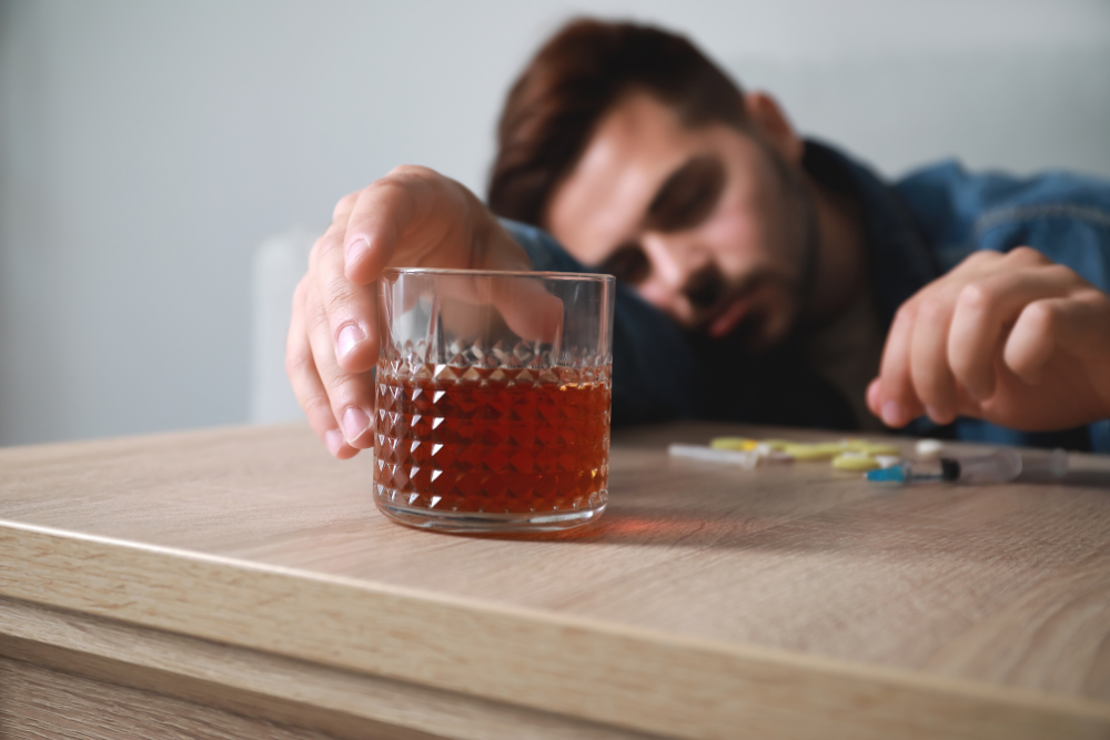 Man dangerously combining Valium with alcohol, increasing the risk of overdose and addiction