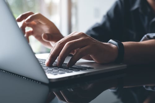 Image of man typing on computer as Avenues Recovery explains what is dopamine detox