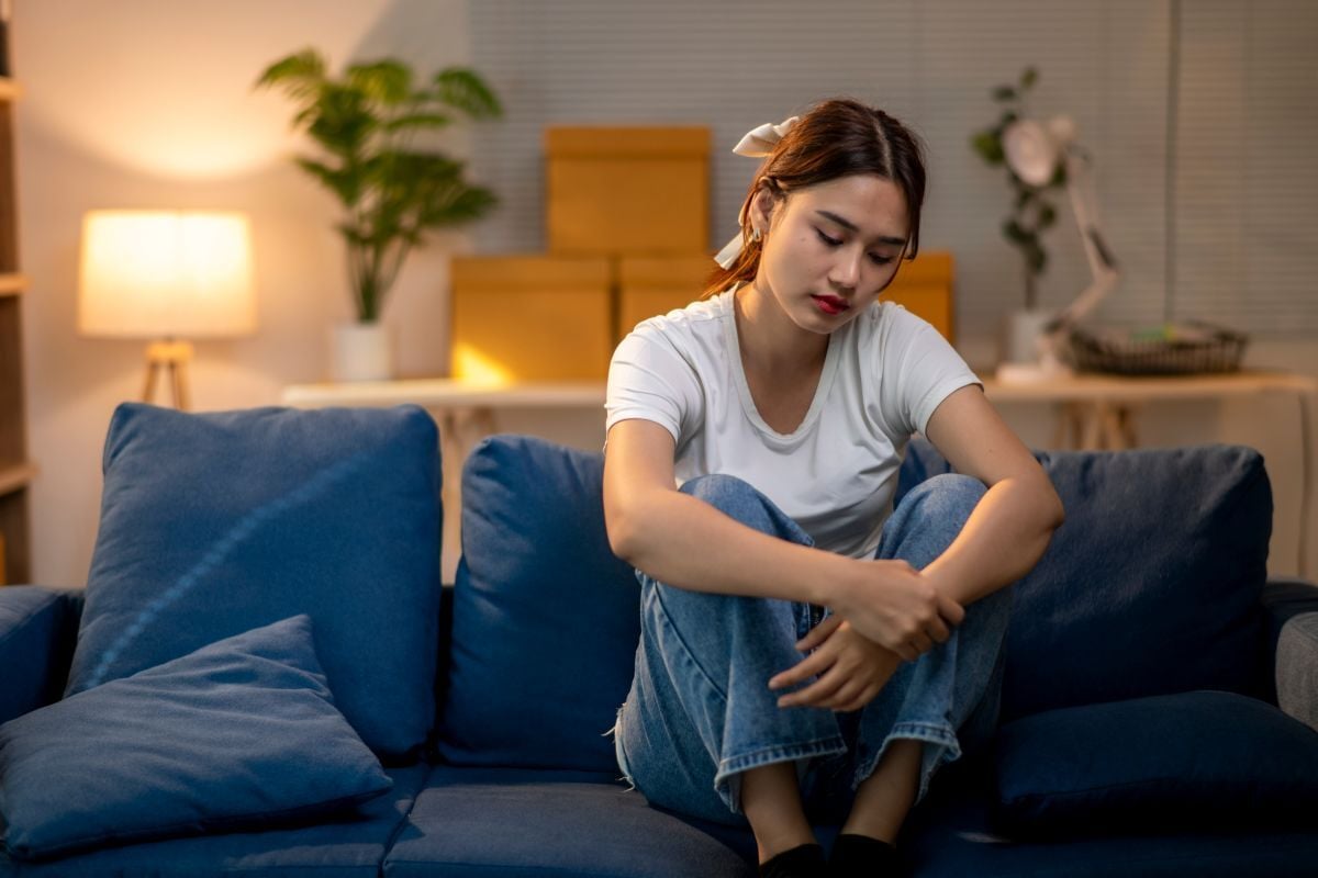 Image of tired woman on couch as Avenues Recovery explores sobriety fatigue