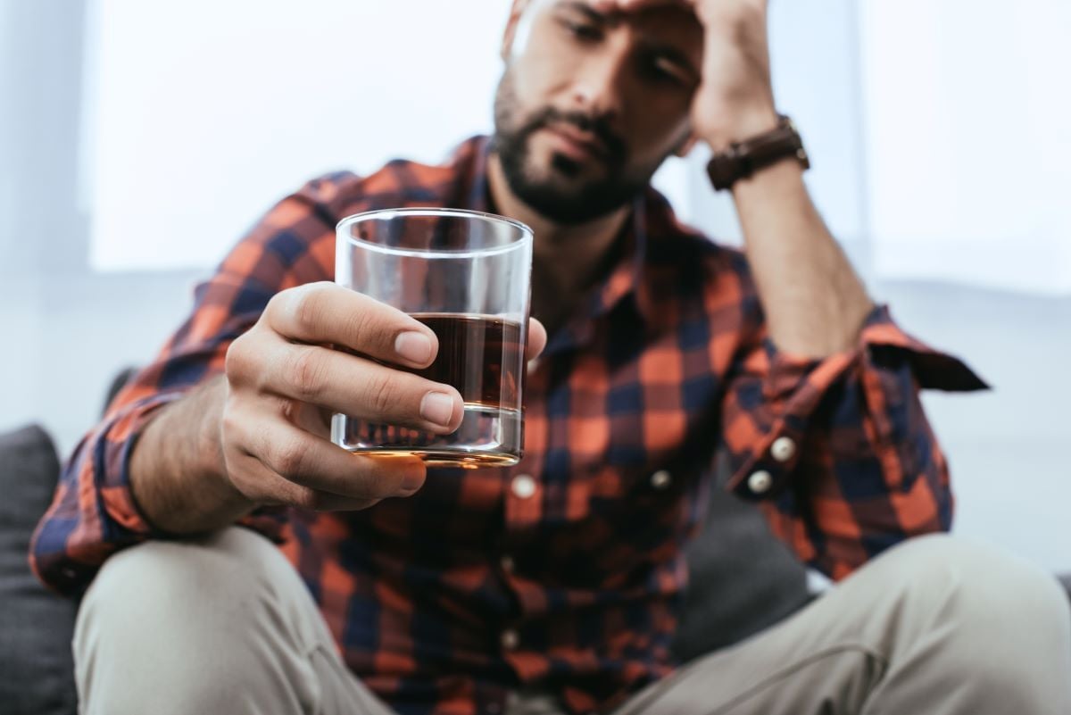 Image of man holding glass of alcohol as Avenues Recovery explores codeine and alcohol