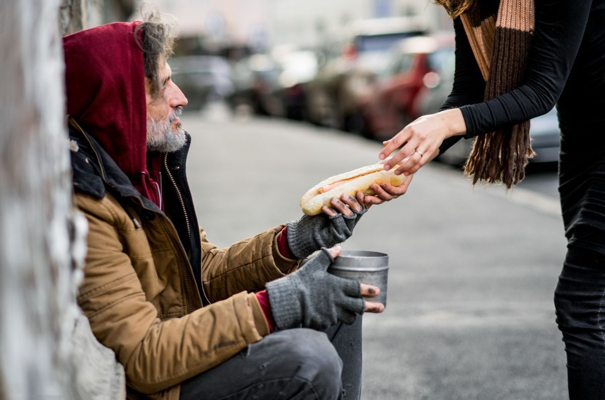 Image of woman feeding homeless man as Avenues Recovery explores volunteer opportunities in Louisiana