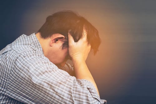 Image of man holding head in hands as Avenues Recovery explains what is anabolic steroid abuse