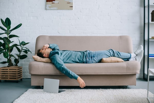 Image of man ill on couch as Avenues Recovery explores the dangers of Vyvanse and alcohol