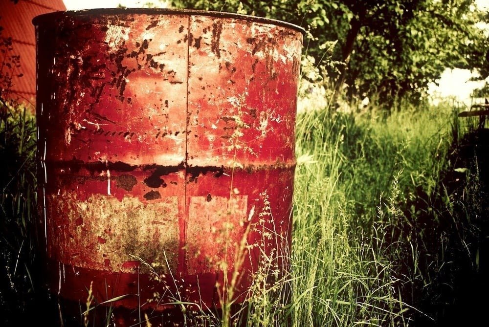 Metal drums and barrels in a grass field, used in the process of making cocaine