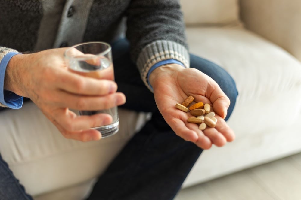 Image of man holding pills as Avenues Recovery explores "is codeine addictive"?