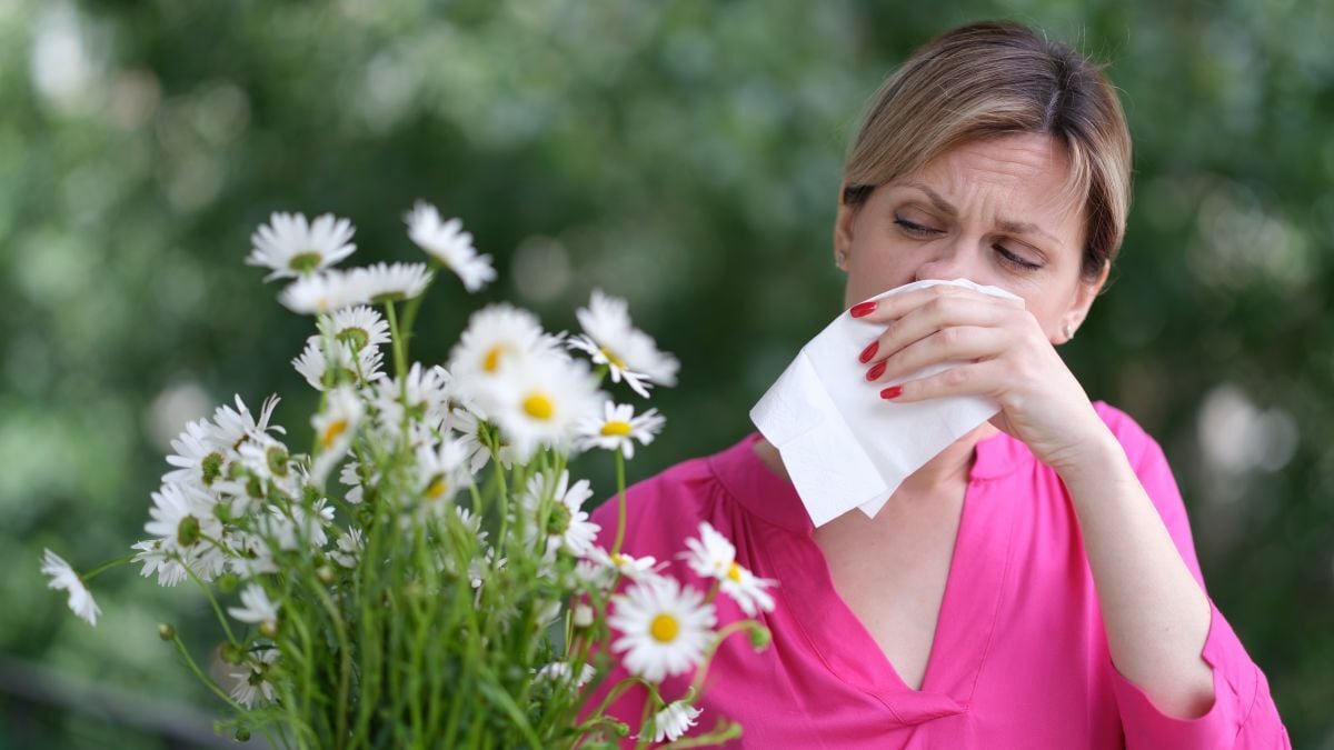 person in a field of flowers sneezing