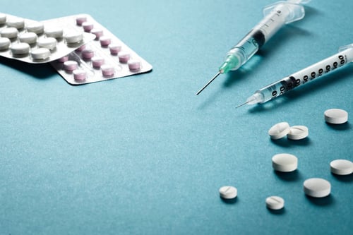 Images of syringes and pills as Avenues Recovery explains what is anabolic steroid abuse