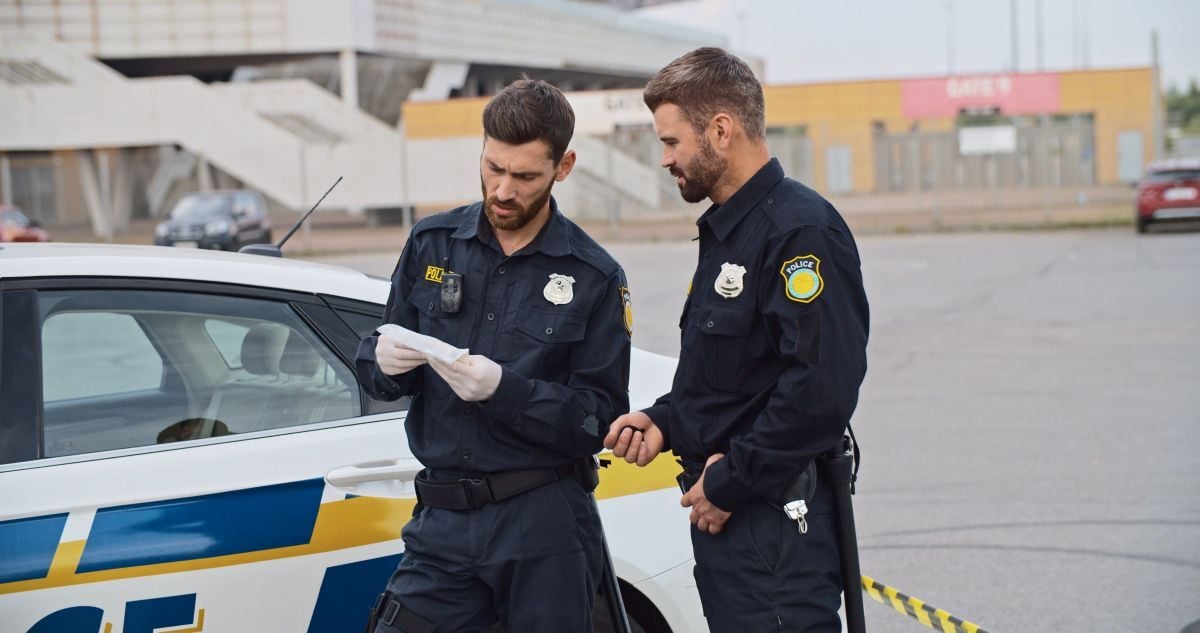 Image of two police officers next to patrol car as Avenues explores Pyro