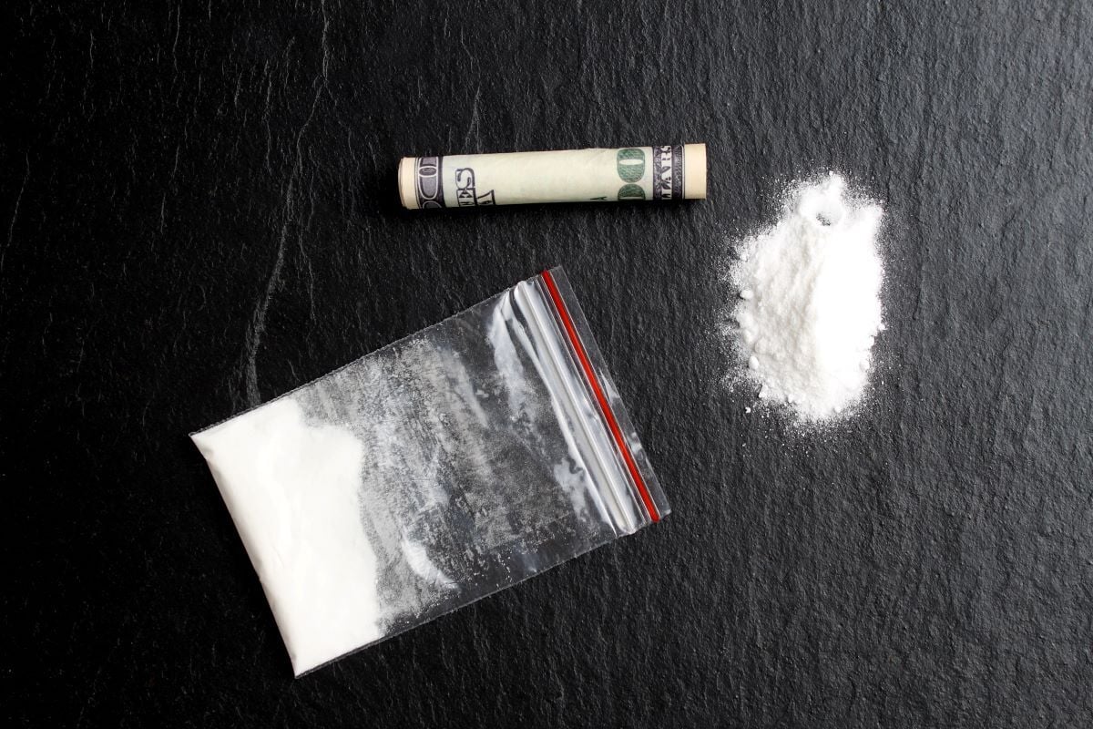 Image of white powdered drug and rolled dollar bill as Avenues Recovery explores designer drugs