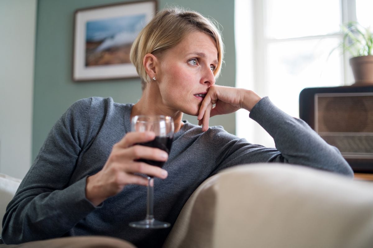 Image of woman on couch holding glass of alcohol as Avenues Recovery explores co-occurring disorders and dual diagnosis