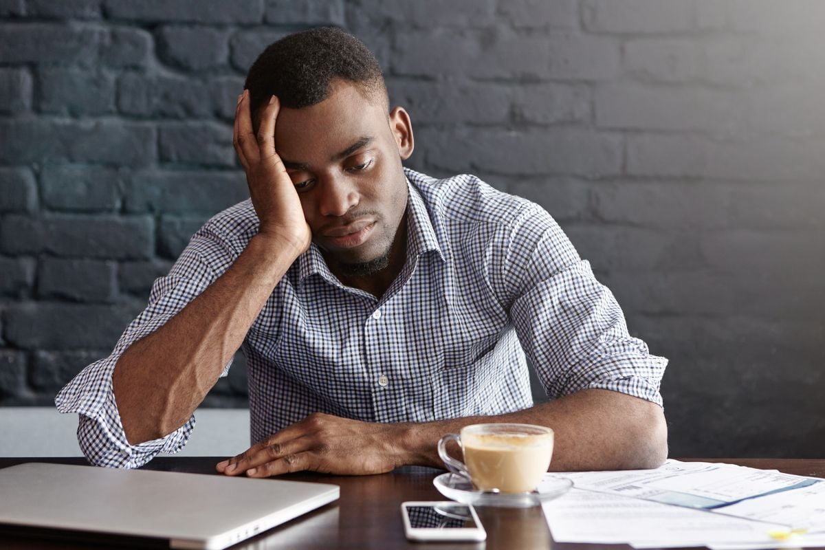 Image of exhausted man at desk as Avenues Recovery explores stress addiction