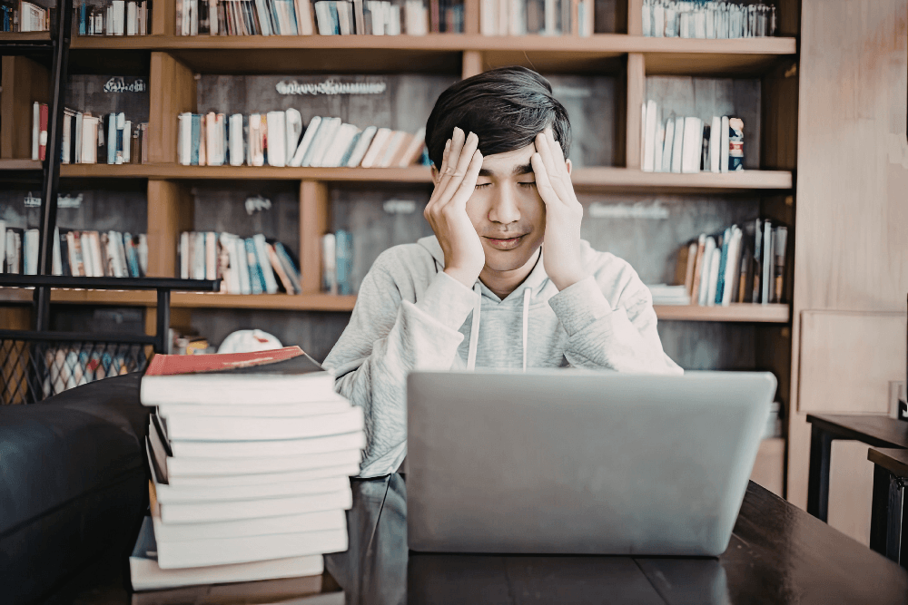 A student overwhelmed with academic pressure, a factor that fuels substance abuse in college students.