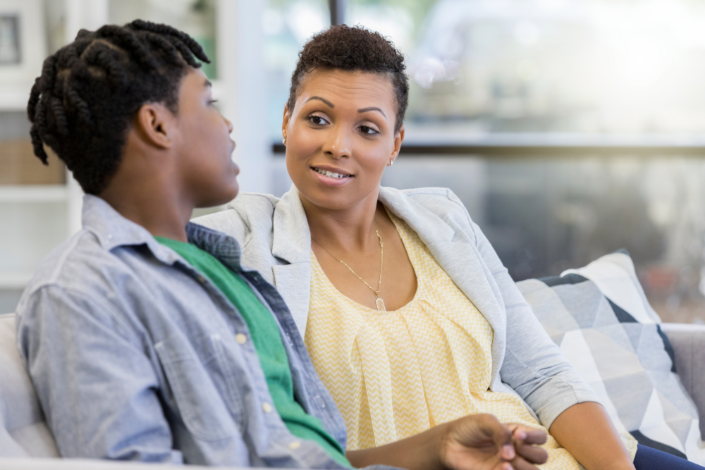 Parent and teenager sitting together, having an open and supportive conversation about drug use.