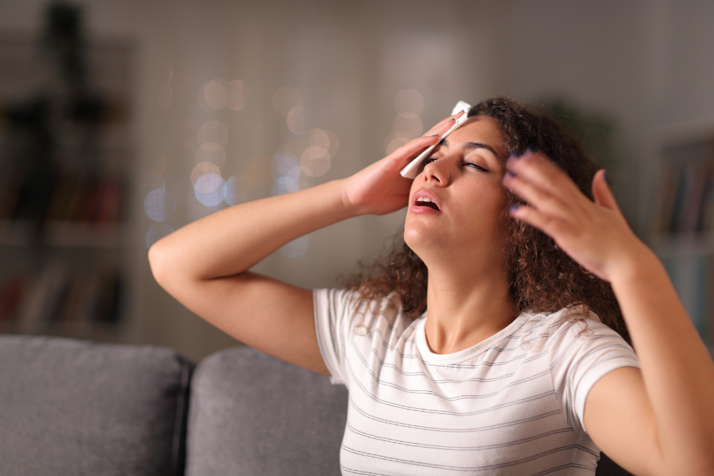 Woman sweating from the dehydrating effects of mixing lithium and alcohol. Avenues Recovery